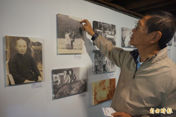 邱晨看著東勢後生添手團基地展示的老照片說，那是他哥哥結婚時因橋被沖斷，只好坐流籠渡溪的珍貴畫面。（記者歐素美攝）