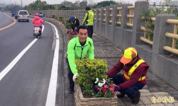 南投縣竹山鎮江西路在「轉角發現幸福」計畫中廣植花卉，予人有煥然一新之感，惟清潔隊長陳東睦（面對鏡頭者）職務異動，令人擔憂該計畫受影響。（記者謝介裕攝）