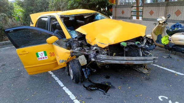 連續衝撞2部機車的計程車，車頭撞得支離破碎。（記者蘇福男翻攝）