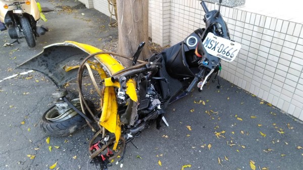 遭計程車衝撞的機車面目全非，計程車的保險桿還卡在機車車架上。（記者蘇福男翻攝）