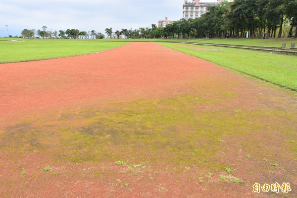 羅東運動公園田徑場為紅土跑道，因羅東多雨，跑道周邊常在雨後積水、滋生青苔。（記者張議晨攝）