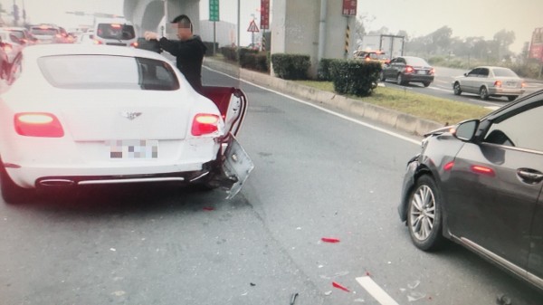 賓利轎車（白）切換車道時遭後車追撞，後保險桿掉落，零件碎片四散。（記者曾健銘翻攝）