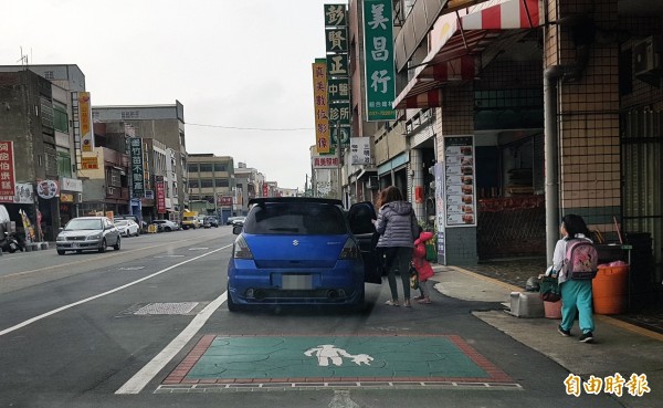 後龍鎮公所在中山路北側路肩,劃設有綠色方格,部分還有「大人牽孩童」圖案,但公所解釋為非通學步道範圍,為警示、美化之用。(記者彭健禮攝)