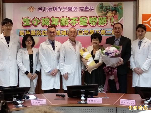 吳女士(抱嬰者)自然產下男嬰,先生(捧花者)在她懷孕過程中全程相伴;長庚醫院醫療團隊也大力幫助。(記者吳亮儀攝)