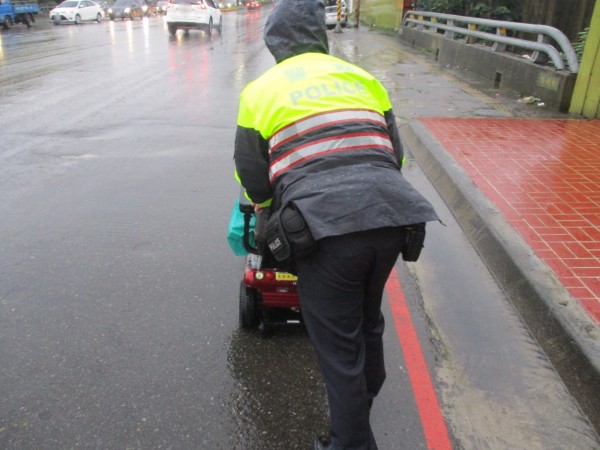 劉姓老翁因電動車雨中沒電卡路中，警推車1.5公里助返家。（記者李容萍翻攝）