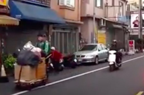 黃柏翔主動幫嬌小的老婆婆(後方紅衣者)推資源回收車,被行車紀錄器錄下。(記者陳昀翻攝)