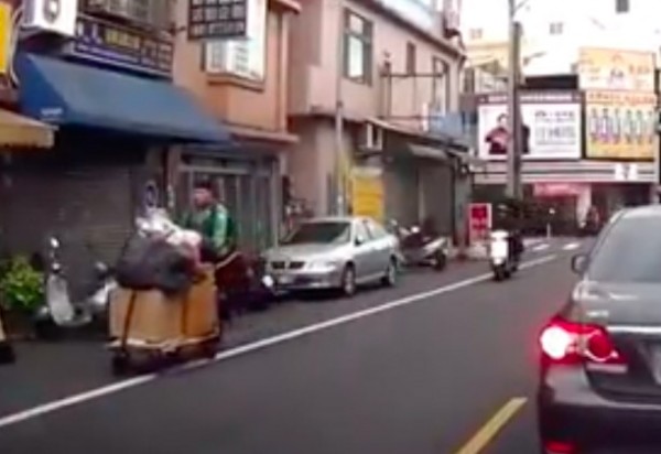 黃柏翔主動幫嬌小的老婆婆(後方紅衣者)推資源回收車,被行車紀錄器錄下。(記者陳昀翻攝)