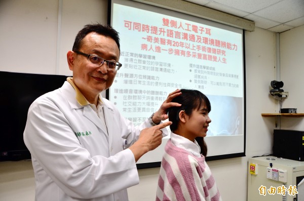 林永松(左)以顏翠亭為例,說明人工電子耳的好處。(記者吳俊鋒攝)