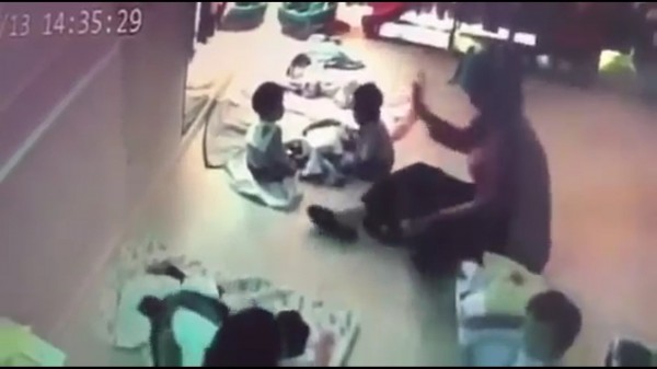 保母用手拍打嬰兒的頭。(記者張瑞楨翻攝自爆料公社)