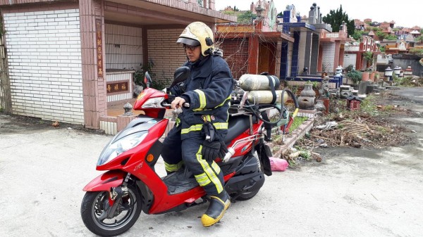 墓地道路狹小，消防隊員利用機車穿梭在墓地救災（記者吳昇儒翻攝）