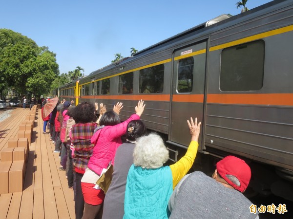 集集鎮綠色隧道隘寮地區新設停車場與火車觀景平台，鎮民熱情參與啟用儀式，並與揮手迎接火車。（記者劉濱銓攝）