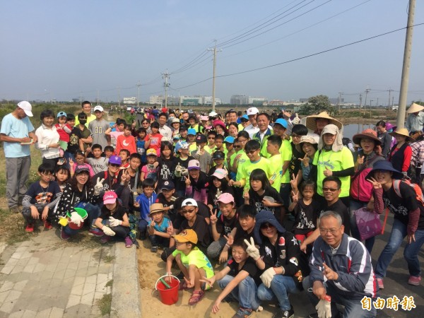 台江NGO老中青三代師生響應世界森林日，參與淨堤植樹。（記者蔡文居攝）