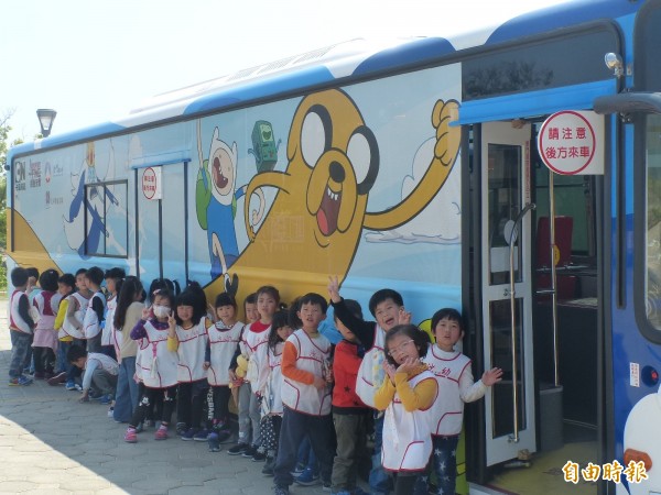 金門縣政府推出彩繪卡通公車,小朋友特別和躍上公車「老皮」等知名人物合影。(記者吳正庭攝)