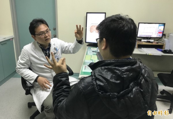 烏日林新醫院神經內科主任宋兆家(左),藉由手部的動作障礙測試,從協調性與反射性研判患者是否罹患帕金森氏症。(記者陳建志攝)