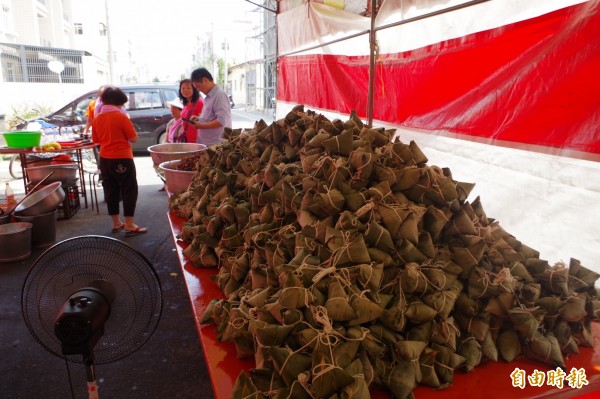 慈惠堂志工趕包素粽迎接大甲媽。(記者林國賢攝)