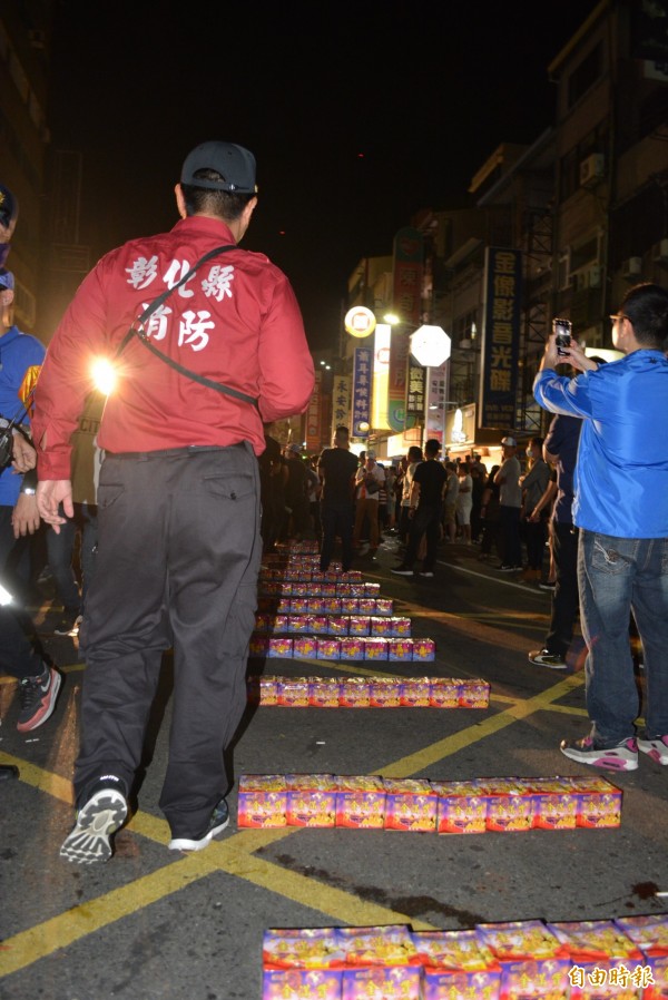 大甲媽半夜遶境彰化市區，陣頭布置地面大批煙火，消防人員立即現身蒐證並沒收。（記者湯世名攝）