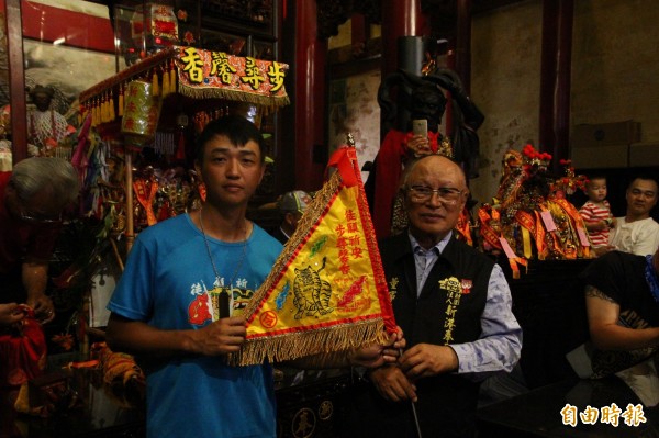 張東耀(左)背著媽祖神像徒步行腳到奉天宮,由董事長何達煌(右)接待。(記者林宜樟攝)
