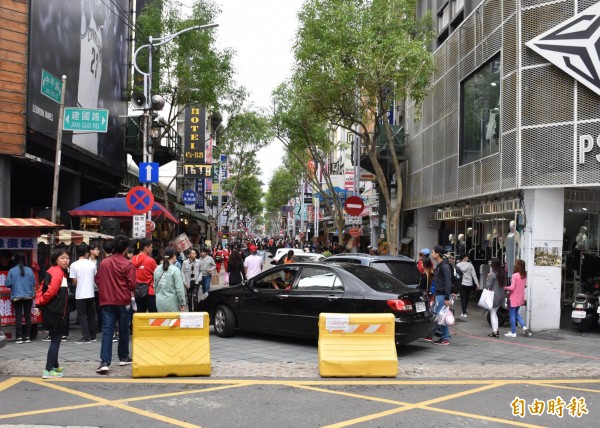 中平商圈車阻器被偷1年,路口的注水式塑膠護欄形同虛設,汽機車想闖就闖,行人必須邊逛邊閃車,險象環生。(記者李容萍攝)