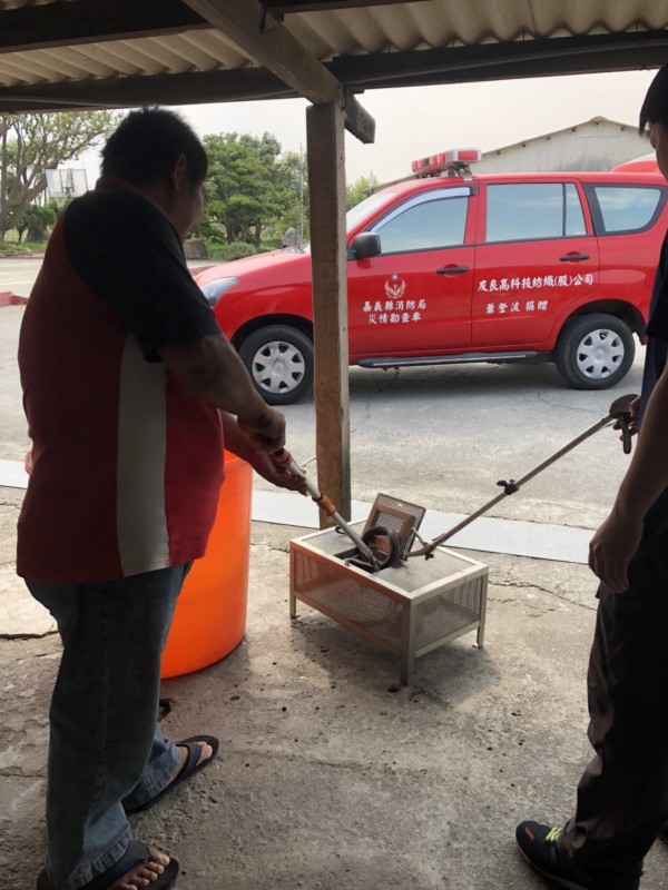 消防隊員逮捕眼鏡蛇，依規定交給相關單位處理。（圖由縣議員戴光宗提供）