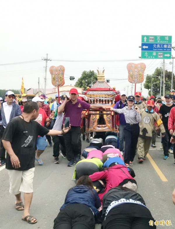 虎尾分局長陳立祺（右抬轎者）首度為媽祖抬轎，沿路信徒列隊「鑽轎腳」。（記者廖淑玲攝）