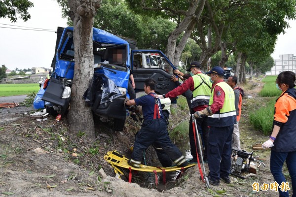 斗南縣道158乙線今天下午發生小貨車撞路樹事故，駕駛受困車內，消防人員以破壞器材搶救。（記者黃淑莉攝）