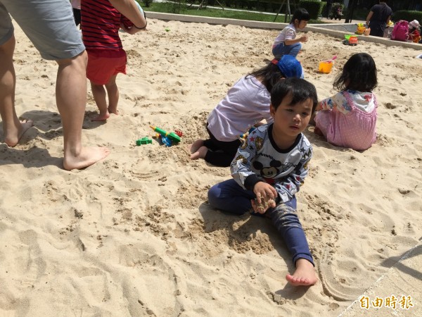 帶著小孩來沙坑玩的家長認為，應該要增設遮陽，不然許多小朋友熱到睜不開眼。（記者邱書昱攝）