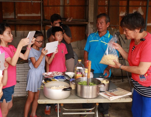 豐榮國小學童深入社區拍攝記錄片，記錄社區傳統飲食文化。（記者林國賢攝）