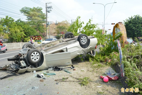 該輛轎車行經花壇鄉省道台一線時接連撞斷路樹、燈桿後翻覆，現場一片狼藉。（記者湯世名攝）