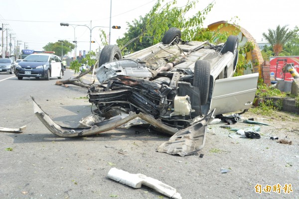 該輛轎車行經花壇鄉省道台一線時接連撞斷路樹、燈桿後翻覆，嚴重毀損。（記者湯世名攝）