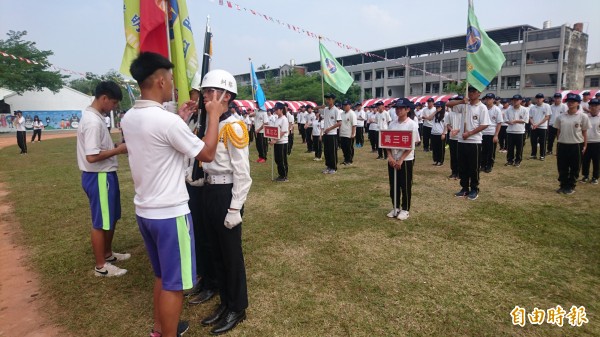 明達校慶今天開幕活動，因天氣熱，學生貼心為儀隊擦去臉上汗水。（記者楊金城攝）