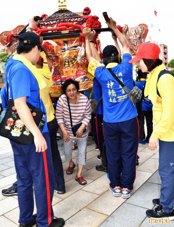 中壢朝明宮媽祖回鑾，信眾排成人龍搶躦轎腳祈福。（記者李容萍攝）