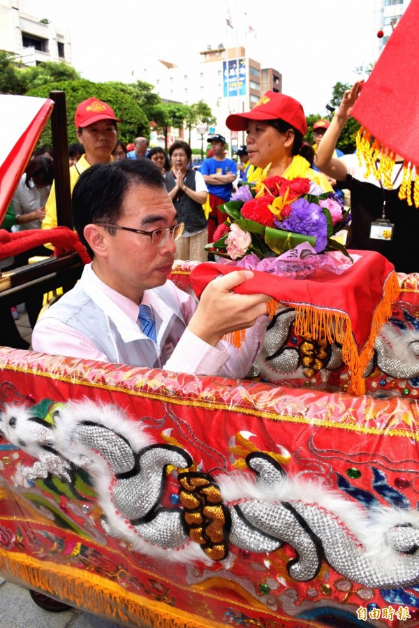 中壢朝明宮媽祖回鑾，中壢區長吳宏國率公所團隊雙手合十迎駕。（記者李容萍攝）