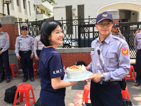 立法委員柯志恩帶著立法院同仁和蛋榚，前往青島東路立法院青島第二會館前，向多日來辛苦執勤的員警，致贈蛋糕表達慰問與謝意，由光明派出所長蔡育憲代表接受。（記者陳恩惠翻攝）