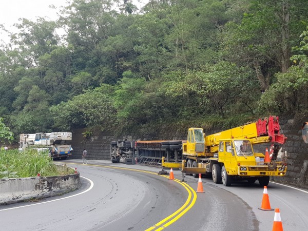 半聯結車今天凌晨側翻在南迴山區，大型吊車天亮後從台東市趕到，協助移開。（記者王秀亭翻攝）