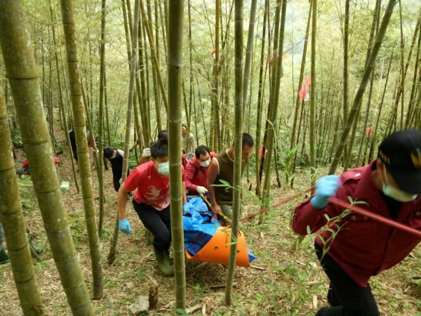 老農巡筍園整地，疑似鋸樹不慎遭壓死，警消尋獲後合力將遺體抬下山。（記者劉濱銓翻攝）