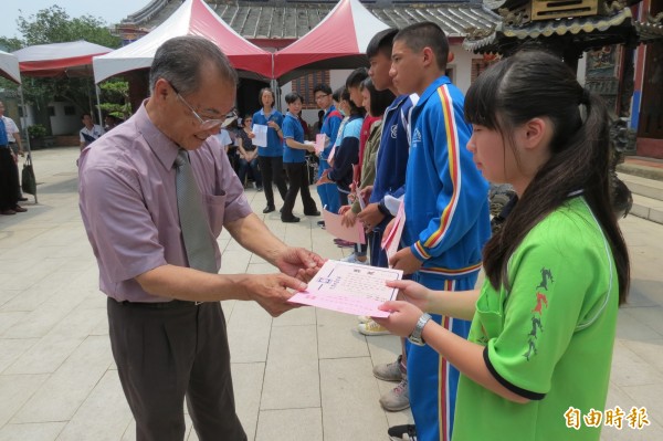 南投縣藍田書院功德會會長李轂摩（左），頒發獎學金及獎狀給縣內590名國、高中學生。（記者張協昇攝）