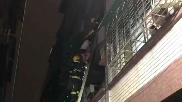 武仁街巷內4樓透天厝今晨火警，消防員協助民眾脫困。（記者黃旭磊翻攝）