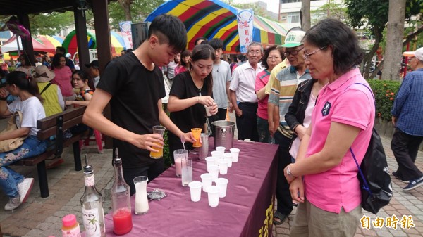 育德工家餐飲科的西瓜特調飲料免費品嘗，民眾排隊。（記者楊金城攝）