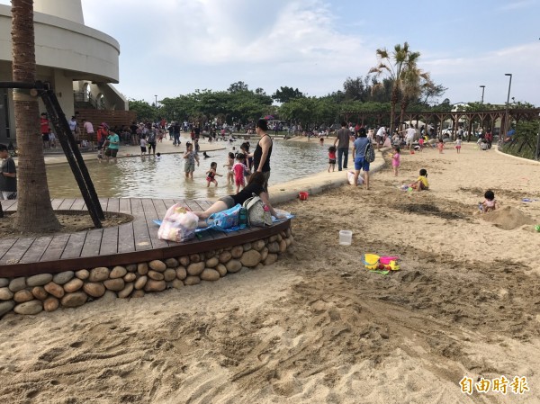 新竹市南寮旅遊服務中心前新完工的親子沙灘，目前正值測試及試放水階段，已吸引許多親子前往玩水玩沙溜滑梯。（記者洪美秀攝）