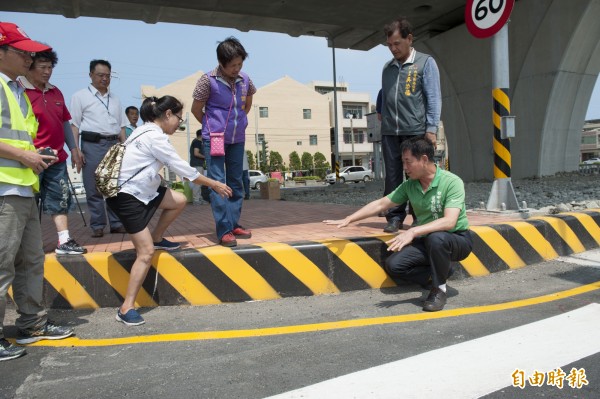 西濱大安段平面交叉路口斑馬線與中央分隔島頭，落差達40公分左右，沒有無障礙坡道。（記者張軒哲攝）