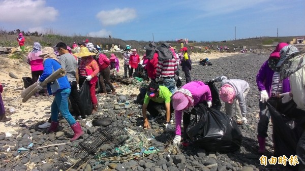 民眾奮力彎腰撿拾海廢垃圾，讓海灘恢復昔日潔淨（記者劉禹慶攝）