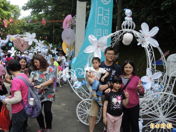 民眾親子同遊，與現場可愛的桐花馬車合影。（記者翁聿煌攝）