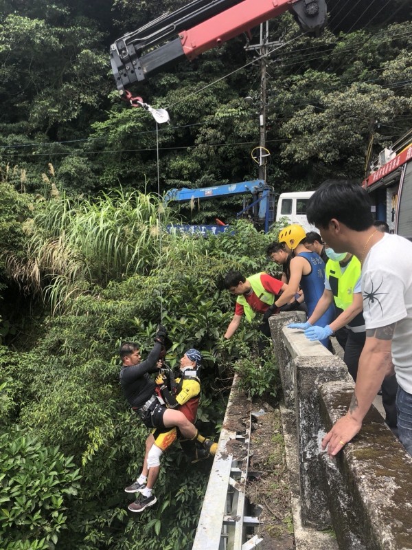 消防人員以吊掛方式將患者拉上橋。（記者徐聖倫翻攝） 