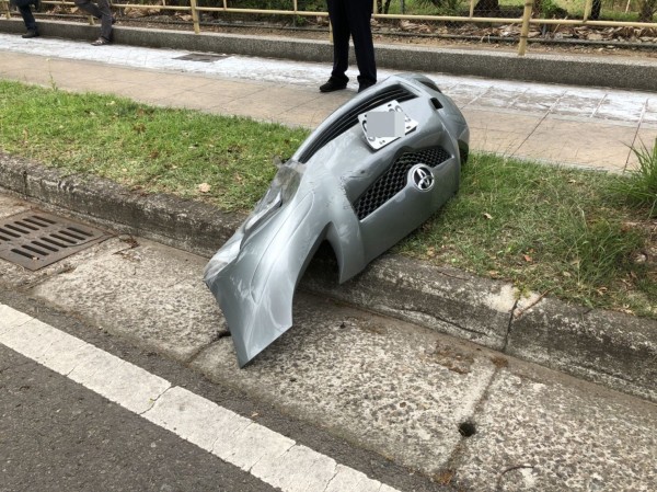 張男駕小客車失控自撞中央分隔島後，反彈至路邊，前保險桿掉落。（記者張勳騰翻攝）