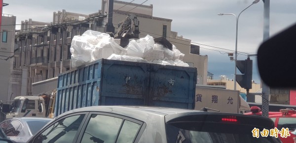 滿載物品的夾子車，行經彰化車水馬龍的交通要道。（記者劉曉欣攝）