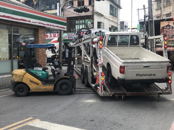 堆高機撐高後方拖板外移以騰出迴旋空間，幫助拖板車脫困。（記者洪臣宏翻攝）