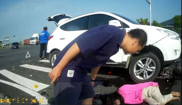 戴姓婦人今晨騎車因發生車禍倒地，機車還卡在車底下。（記者王善嬿翻攝）