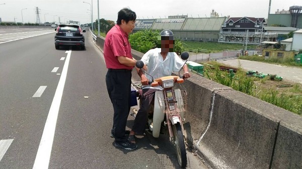 休旅車先攔下阿公，陳力仁阻止阿公騎車逆向沿路肩下新營交流道，最後幫他牽機車。（記者楊金城翻攝）