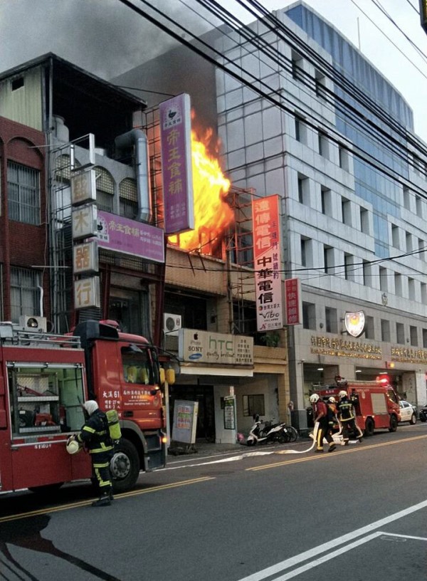 熊熊大火和濃煙從大溪民宅3樓的神明廳不斷竄出，消防人員全力灌救。（記者李容萍翻攝）