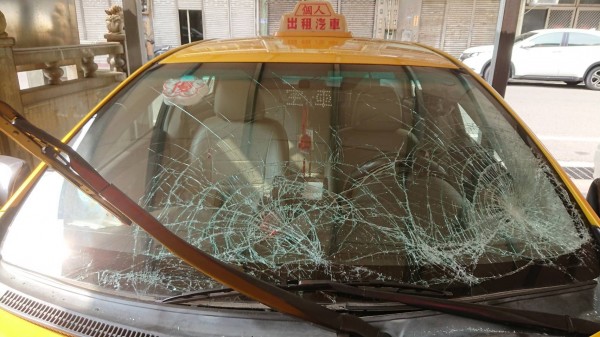 計程車遭到池魚之殃,擋風玻璃及引擎蓋全毀。(記者吳昇儒翻攝)